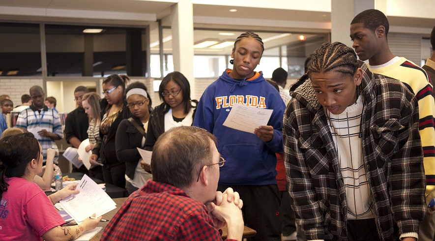 ... job seekers talk to prospective employers at a teen job fair held at